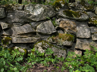 Old stones and moss on a stone wall. Green grass. 
