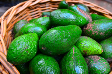 Fresh green Avocados in a basket