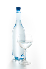 Glass of water with a bottle isolated on white