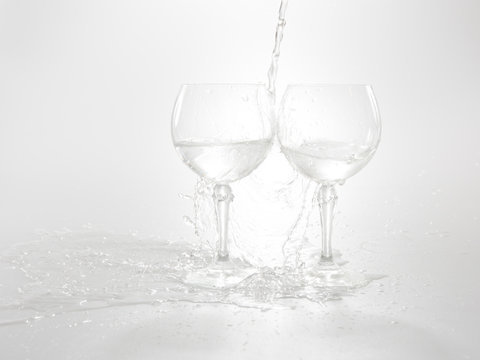 Water Is Pouring In Two Wine Glasses