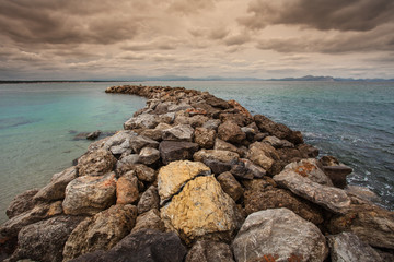 The breakwater at San Pedro Beach in Betlem, Mallorca, looking over Alcudia Bay towards Cap des Pinar and Cap de Formentor.
