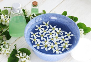 Obraz na płótnie Canvas Herbal cosmetic products. Blue ceramic bowl flower water, fresh flowers, cleansing facial tonic. Botanical skincare.