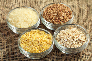 various cereals in glass bowls on a burlap closeup