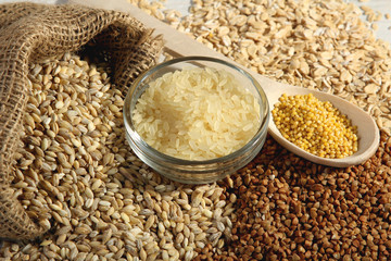 a variety of grains in wooden spoon and bowl with a bag closeup