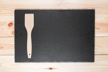 wooden spatula on slate board, top view