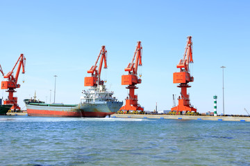 In freight terminal, gantry crane and cargo ships are in loading