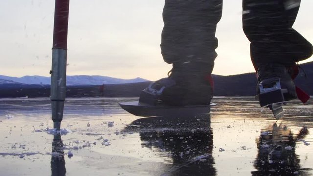 An ice skating enthusiast testing the ice on a lake in swedish mountains using an ice prod