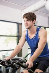 Plakat Man working out on exercise bike at spinning class