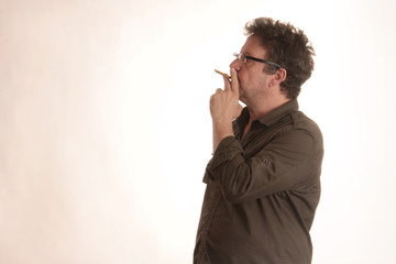 Ein Mann mit Brille raucht Zigarillo