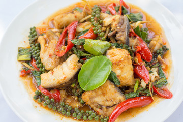 Puff savory fish kang put fresh green peppercorns on dish.