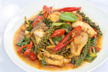 Puff savory fish kang put fresh green peppercorns on dish.