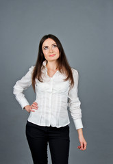 Thoughtful woman looking away while thinking. Business girl in wite blouse. She stands and recalls. 