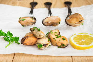 Stewed mussels pinned on forks.