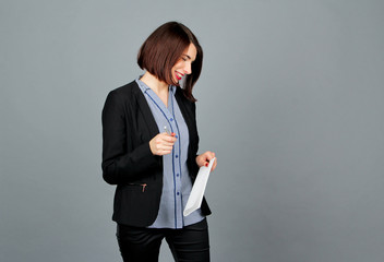 Thoughtful woman looking away while smile. Write on notes. Business girl. She stands and recalls....