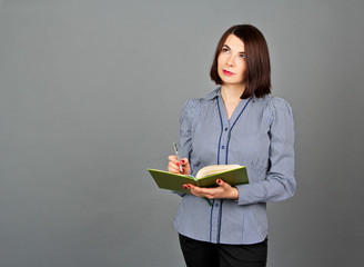 Thoughtful woman looking away while thinking. Write on her notes. Business girl. She stands and...