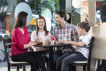 Family In Casuals Having Ice Creams In Parlor