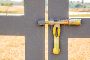 Grunge yellow bolt of entrance door in Farmland.