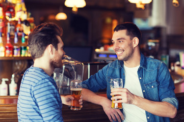 happy male friends drinking beer at bar or pub