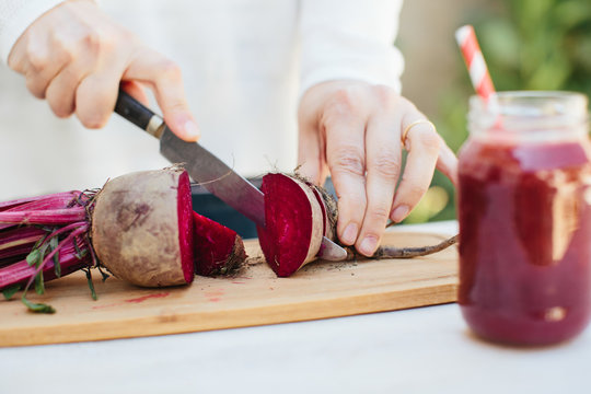 Close-up of hands preparing a beet juice