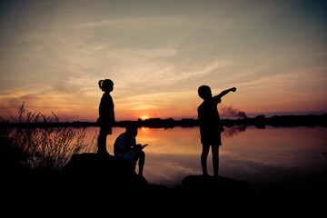Fototapeta na wymiar silhouette children playing happy time at sunset