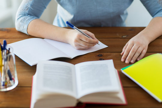 close up of student with book and notebook at home