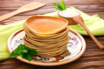 Stack of pancakes with mint and sour cream