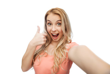 Fototapeta premium happy woman taking selfie and showing thumbs up