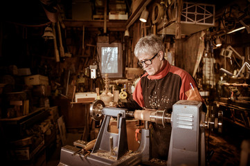 Woodturners using a rotating clamp to turn the wood.