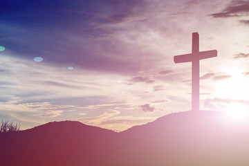 cross silhouette on the mountain at sunset