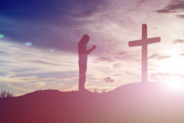 Fototapeta na wymiar woman pray with cross silhouette, god concept