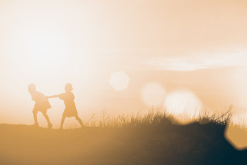 silhouette children playing happy time at sunset