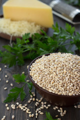 Pearl barley, herbs and cheese, the ingredients for a tasty and healthy breakfast on the wooden table