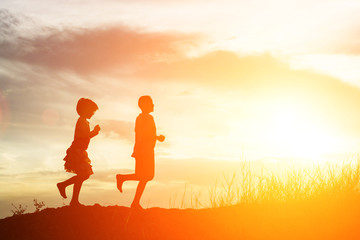 silhouette of boy and girl running