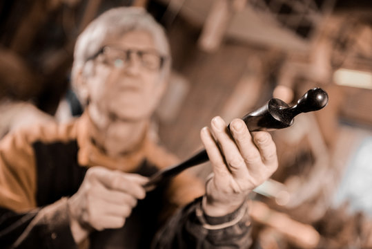 Woodturners using a rotating clamp to turn the wood.