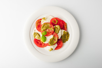 Caprese salad on a ceramic plate on a white table