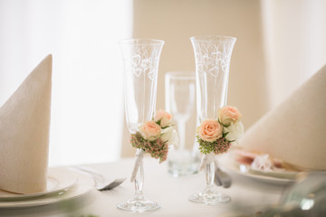 Beautiful wedding decoration on glasses in restaurant