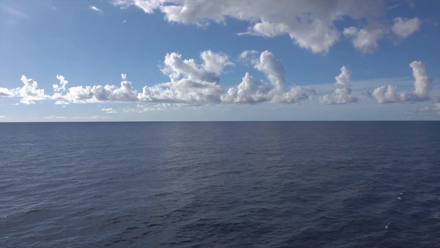 Dolly shot over cruise ship railing to blue sky