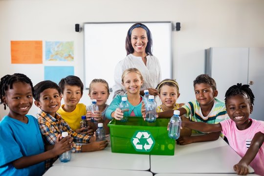 Portrait of pupils and teacher recycling 