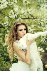 Naklejka premium Woman with goat in blossom