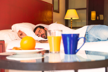 Continental breakfast and man sleeping in a hotel