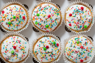 Vanilla cupcakes with white glaze, cupcake packaging, delivery box, top view, selective focus, close up