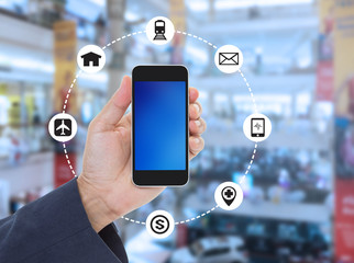 Hand holding blank screen mobile phone on blurred shopping mall
