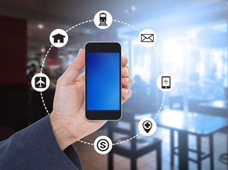 Hand holding blank screen smartphone on blurred coffee shop back