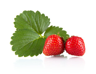 Two whole strawberries with leaf isolated on a white