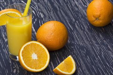 Orange juice in glass,  fresh fruits on wooden background