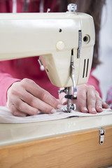 Sewing Process - Women's hands behind her sewing machine
