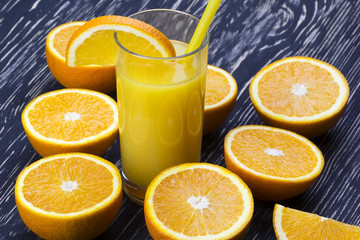 Orange juice in glass,  fresh fruits on wooden background