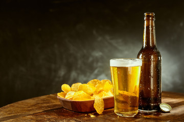Cold beer and potato crisps on a bar counter
