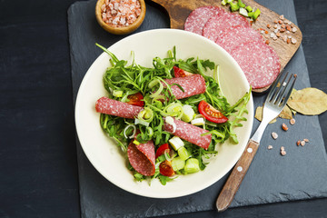 Arugula with salami salad with onions and tomatoes