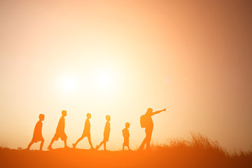 Silhouette father walking with children go to travel